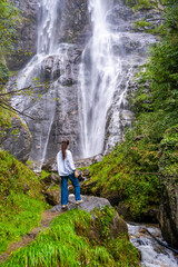 Fototapeta premium Young woman near waterfall in San Pietro town in Italy