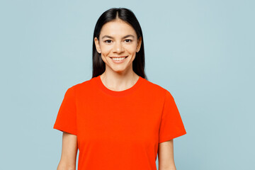 Young smiling happy cheerful satisfied cool latin woman wears orange red t-shirt casual clothes looking camera isolated on plain pastel light blue cyan background studio portrait. Lifestyle concept.
