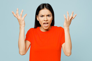 Young displeased sad mad latin woman wear orange red t-shirt casual clothes spead hands scream...