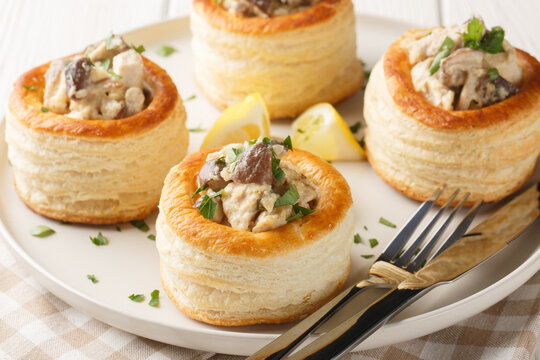 Delicious classic vol-au-vent stuffed with chicken, mushrooms in a creamy sauce close-up in a plate on the table. horizontal