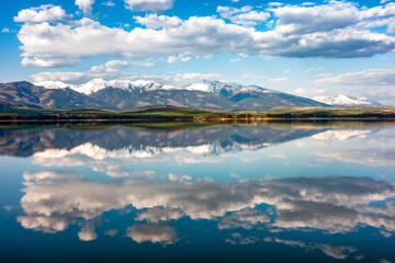 Reflection of snowy peaks in calm lake