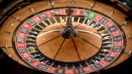 Naklejka premium Roulette table in a casino, with many games and slots, roulette wheel in the foreground. Golden and luxurious light, casino interior. Gambling is betting on money or gambling for money.