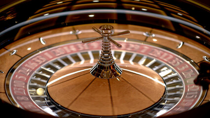 Roulette table in a casino, with many games and slots, roulette wheel in the foreground. Golden and...