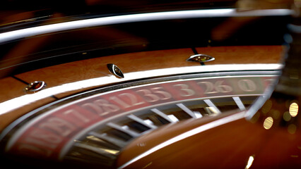 Roulette table in a casino, with many games and slots, roulette wheel in the foreground. Golden and luxurious light, casino interior. Gambling is betting on money or gambling for money.
