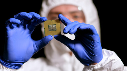 Engineer man in sterile suit is holding Microchip with symbols in modern design factory , futuristic and artificial intelligence concept