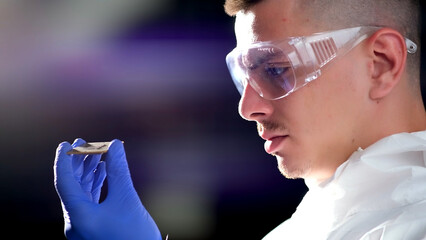 Close up portrait of a young computer engineer with a microchip.