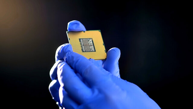 The scientist works in a modern scientific laboratory for the research and development of microelectronics and processors. Microprocessor manufacturing worker uses computer technology and equipment.