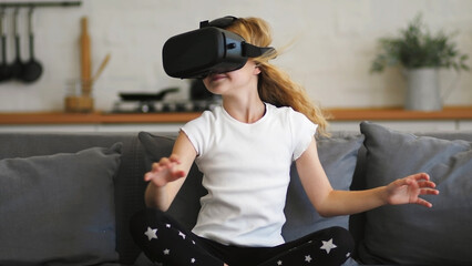 Beautiful girl in a virtual reality headset. Augmented reality. Happy cute girl touching something...
