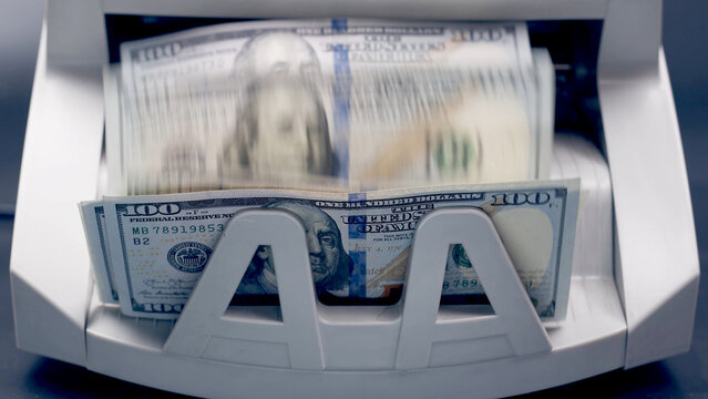 electronic money counter machine is counting is counting the American hundred-dollar (US dollars) banknotes