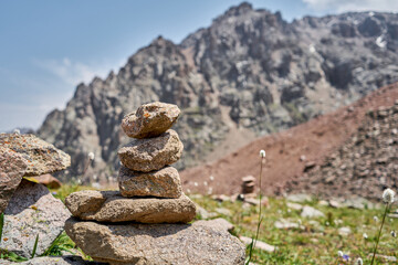 Zen balanced stones stack in high mountains. Pyramidal of stones against the backdrop of a picturesque mountain valley. Moraine in the highlands of Kazakhstan.