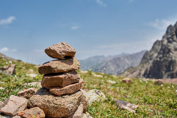 Zen balanced stones stack in high mountains. Pyramidal of stones against the backdrop of a picturesque mountain valley. Moraine in the highlands of Kazakhstan.
