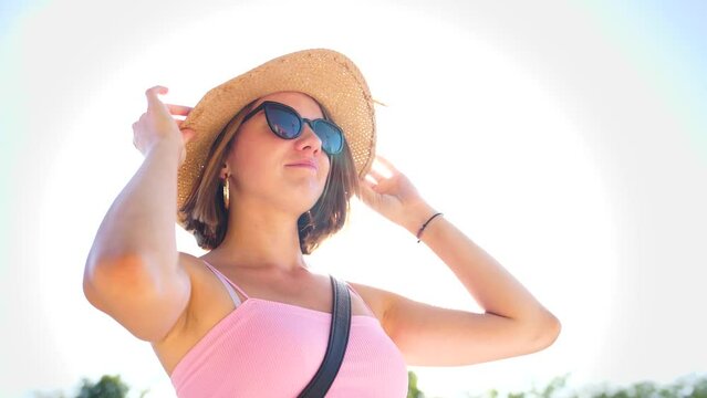 smiling face blonde woman with sunglasses, attractive female, pretty girl with straw hat, earrings, shades smiles, slow motion slomo, pink sexy top, sunflare sunny portrait, adult model gen z hipster
