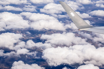 Obraz premium Clouds and plane wing, view from window plane