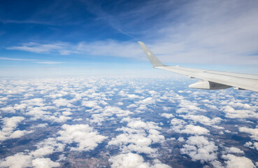 Fototapeta na wymiar Clouds and plane wing, view from window plane