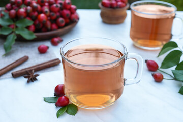 Dog rose, bunch branch Rosehips, types Rosa canina hips and herbal tea. Medicinal plants herbs composition. Healthy ingredient. Alternative medicine and herbal therapy concept. Side view.