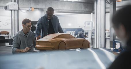 Female Drawing a Vehicle Sketch on a Digital Tablet. Clay Car Modeler Advising with Aerodynamics Engineer on Creating a 3D Polymer Model of a Modern Electric Car. Team of Specialists Working in Agency