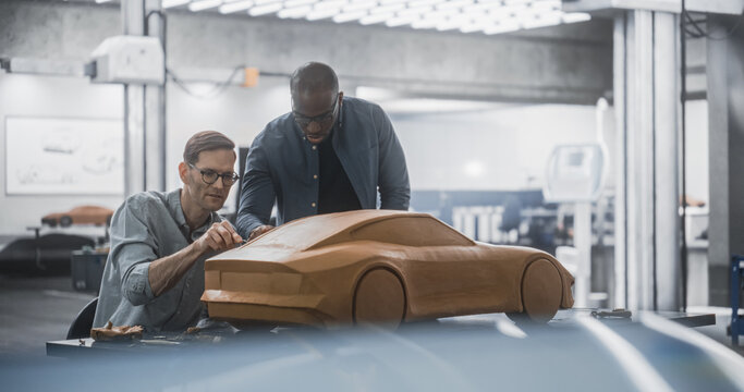 Enthusiastic Teamwork of Two Diverse Creative Colleagues Working in an Automotive Development Design Agency. Professional Sculptor Working Together with an Engineer, Discussing the Prototype Vehicle