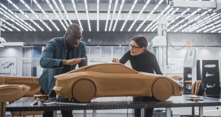 Enthusiastic Teamwork of Two Diverse Creative Colleagues Working in an Automotive Development...