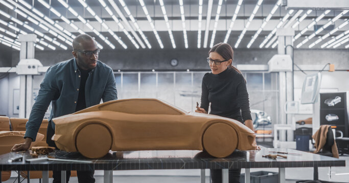 Enthusiastic Teamwork of Two Diverse Creative Colleagues Working in Automotive Development Design Agency. Professional Sculptor Working Together with an Engineer, Discussing Prototype Vehicle