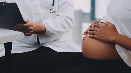 Happy pregnant woman visit gynecologist doctor at hospital or medical clinic for pregnancy consultant. Doctor examine pregnant belly for baby and mother healthcare check up. Gynecology concept.