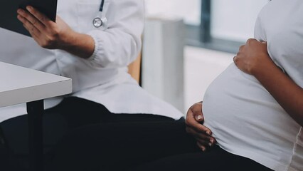 Happy pregnant woman visit gynecologist doctor at hospital or medical clinic for pregnancy consultant. Doctor examine pregnant belly for baby and mother healthcare check up. Gynecology concept.