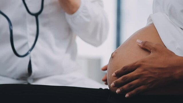Happy pregnant woman visit gynecologist doctor at hospital or medical clinic for pregnancy consultant. Doctor examine pregnant belly for baby and mother healthcare check up. Gynecology concept.