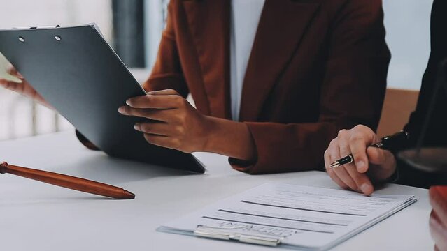 Business and lawyers discussing contract papers with brass scale on desk in office. Law, legal services, advice, justice and law concept picture with film grain effect