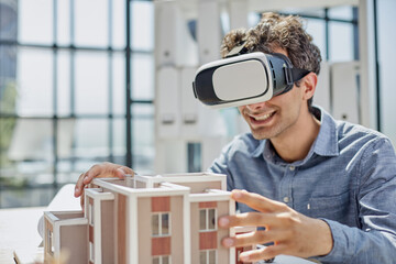 man sits in the office of a realtor and looks at the layout of the apartment in virtual reality glasses.