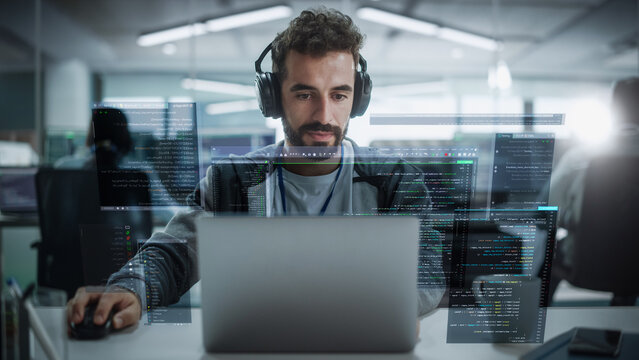 Young Hispanic Male Software Developer Working in Technological Start-Up Office. Latin Specialist Programming Monitoring Solutions. VFX Hologram Edit Visualizing Coding Interfaces, Opened Windows