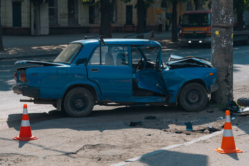 Obraz na płótnie Canvas Broken bumper and hood of a car as a result of a collision with a pole, close-up. The car crashed into a lamp post. car accident