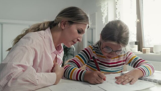 Mother helping daughter in doing homework. Shot with RED helium camera in 8K.