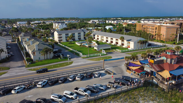 Busy parking lot near row of beach condominium, vacation rentals and restaurant along 98 Scenic Gulf Drive in Walton, Florida, America