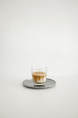 A glass of dirty coffee at white background
