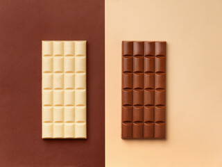 White and dark chocolate on contrasting backgrounds, top view, copy space