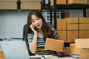 young asian women using smartphone contacted a customer asking for a shipping address.