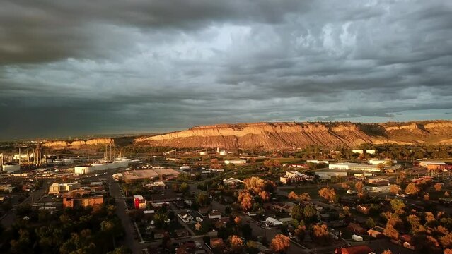 Aerial Shot Of Houses Near Factory And Mountains At Sunset, Drone Flying Forward Over City Against Cloudy Sky - Great Falls, Montana