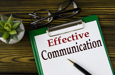 EFFECTIVE COMMUNICATION - words on a white sheet on a brown wooden background with a pen and glasses