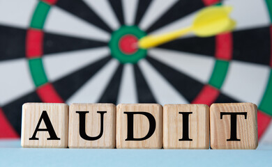 AUDIT - word on wooden cubes on dartboard background