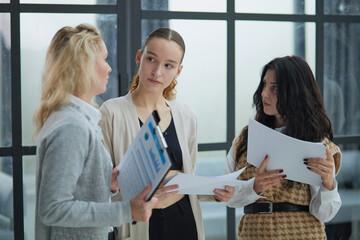 Serious people are holding a folder and writing on papers while colleagues