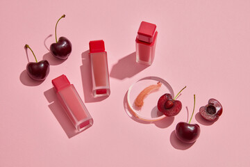 Scene for branding products. Red ripe cherries with lipsticks unbranded arranged on pink...