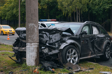 Broken bumper and hood of a car as a result of a collision with a pole, close-up. The car crashed...