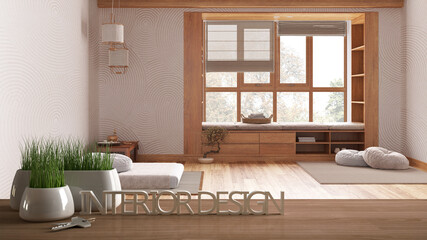 Wooden table, desk or shelf with potted grass plant, house keys and 3D letters making the words interior design, over minimal meditation room, project concept copy space background