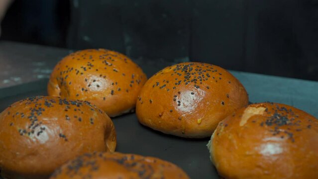 Fresh hot barely oven hanburger buns bun sesame seed over stainless steel table at gourmet restaurant kitchen