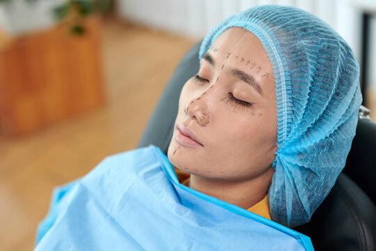 Woman sitting in chair in office of plastic surgeon waiting for facelift surgery