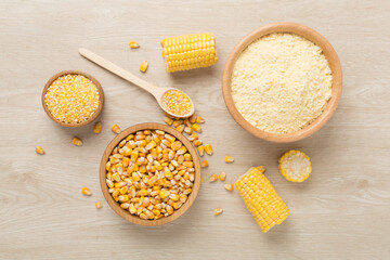 Maize products with fresh corn cobs on wooden background, top view
