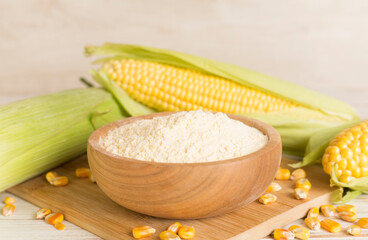Corn flour with fresh cobs on wooden table