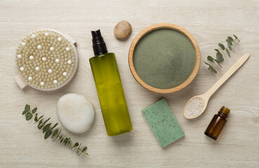 Composition with cosmetic clay and spa products on wooden background, top view