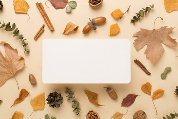 Greeting card mockup with autumn leaves on color background, top view