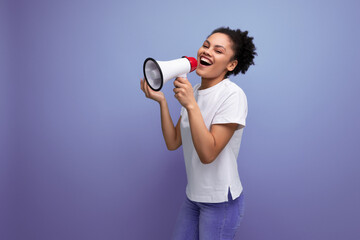 young pretty hispanic business music lover woman in white t-shirt announces important advertisement with megaphone