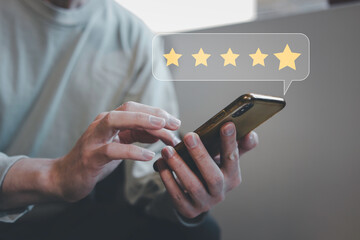 customer service evaluation and feedback rating. costumer review concept, man using phone chooses happy smiling face